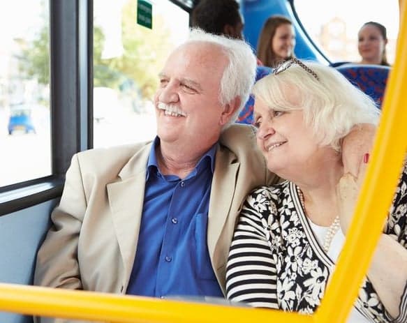Ouder echtpaar kijken naar buiten met een glimlach