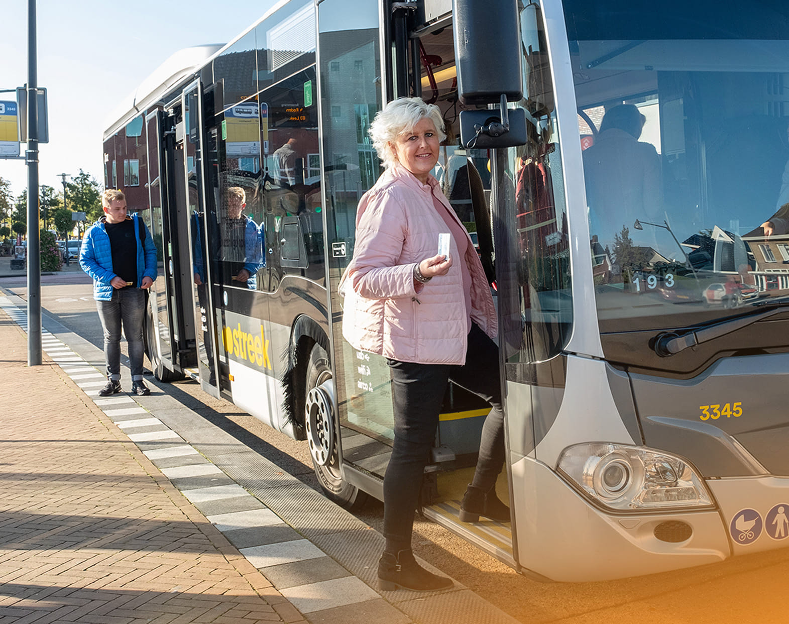 Oudere dame stapt in de bus